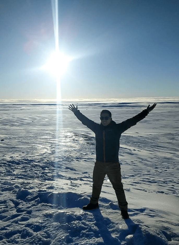 David standing with his arms raised in a snowy Icelandic landscape